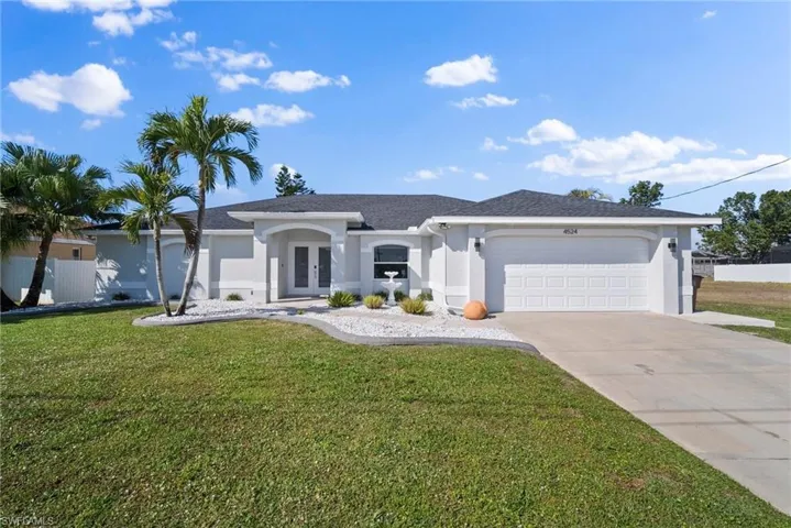 Ranch-style home with french doors, stucco siding, a front lawn, and an attached garage