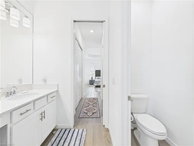 Bathroom with light wood-style floors, vanity, recessed lighting, and ensuite bath