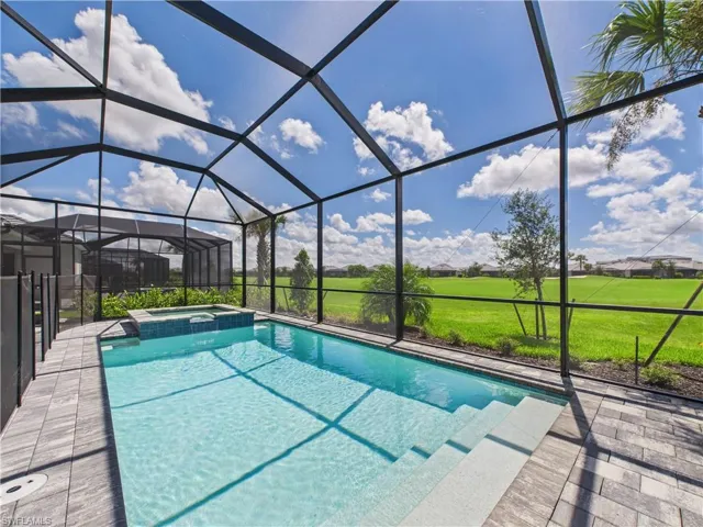 View of swimming pool with a sunroom, a pool with connected hot tub, and glass enclosure