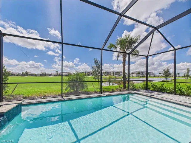 Outdoor pool with a sunroom, a water view, a lanai, and a lawn