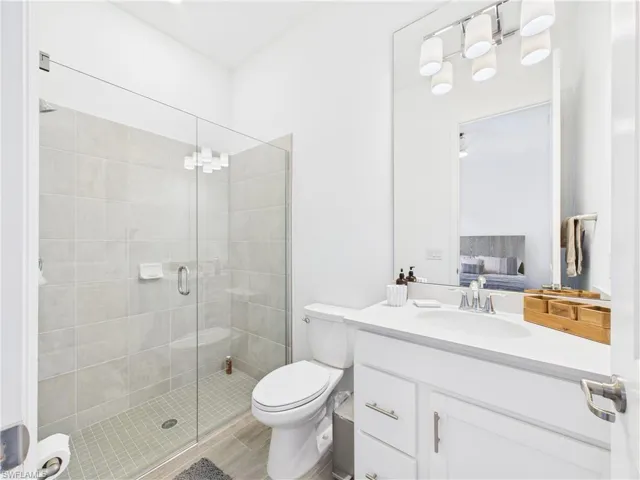 Ensuite bathroom with vanity, a stall shower, and a chandelier