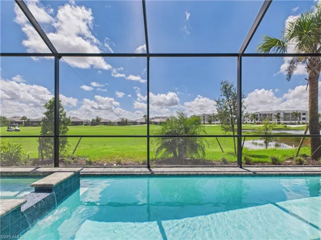 Swimming pool featuring a sunroom, a water view, and a lanai