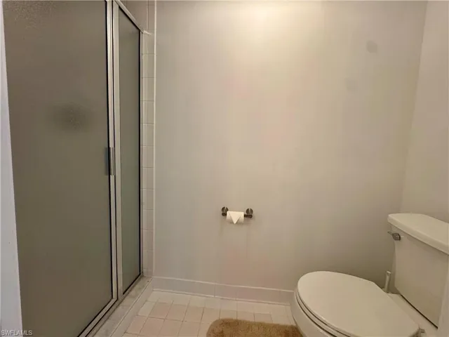 Bathroom with a stall shower and light tile  floors