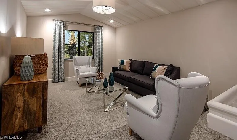 Carpeted living room featuring vaulted ceiling and recessed lighting