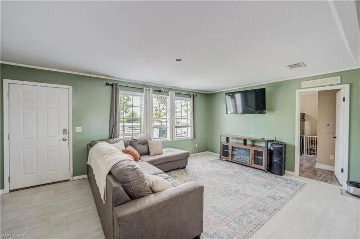 Living area with light green walls and light-toned flooring