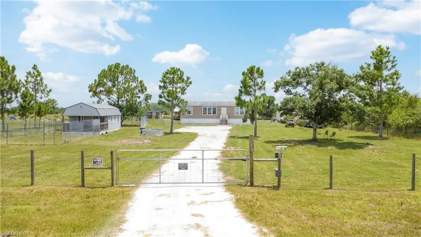 Gated entry with a gravel driveway leading to the residence