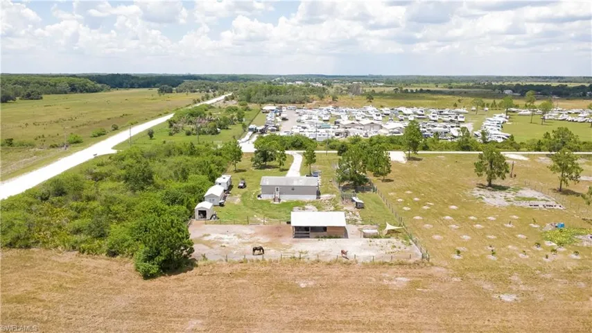 Expansive acreage featuring a main residence, an outbuilding, and multiple storage sheds