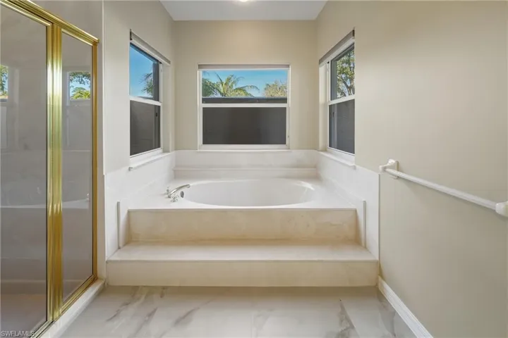 Full bathroom featuring a shower stall and a bath