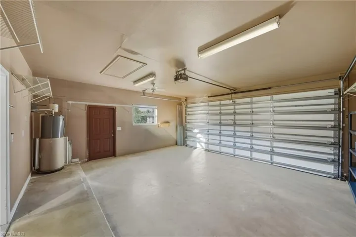 Garage featuring water heater and a garage door opener