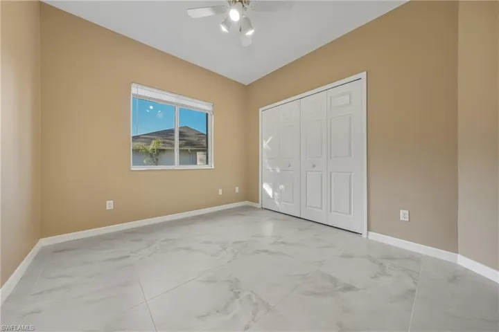 Unfurnished bedroom with a ceiling fan and a closet