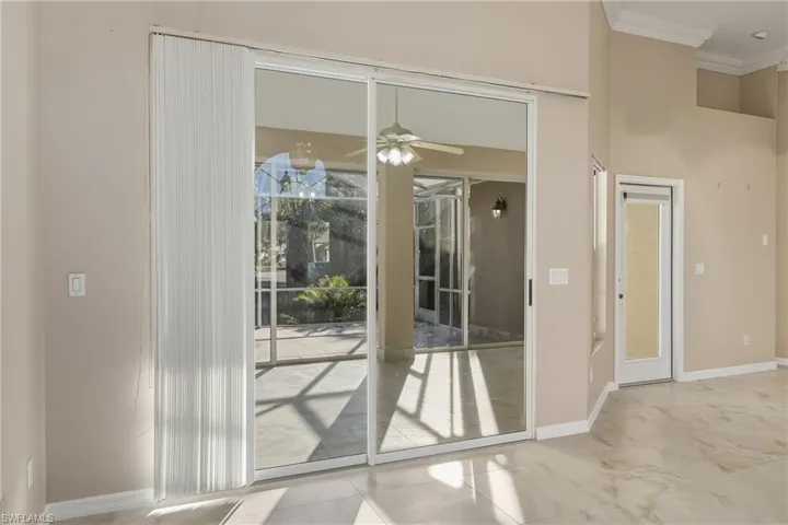 Doorway with crown molding and a ceiling fan