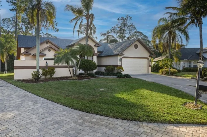 Single story home featuring a front lawn, driveway, an attached garage, and stucco siding