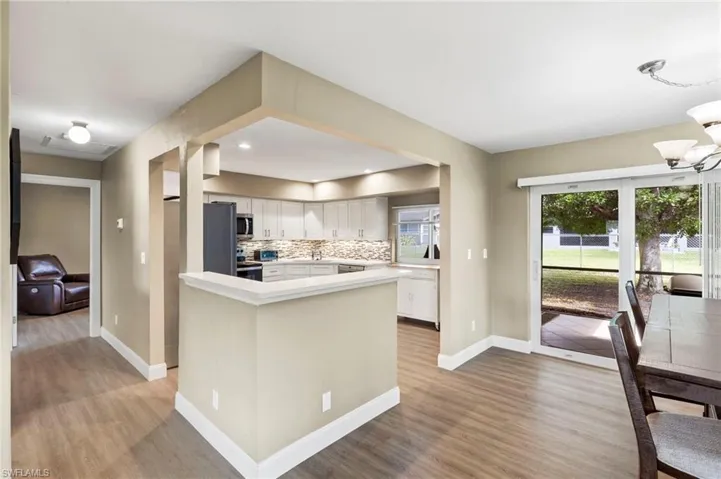 The open floor plan flows smoothly from the newly remodeled kitchen into the dining area and living room, creating a seamless and inviting space.