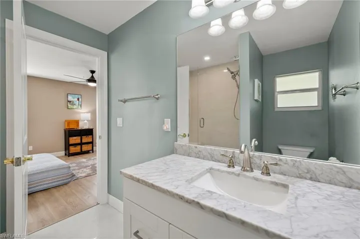 This primary bathroom has floor-to-ceiling tiled enclosed shower and quartz vanity.