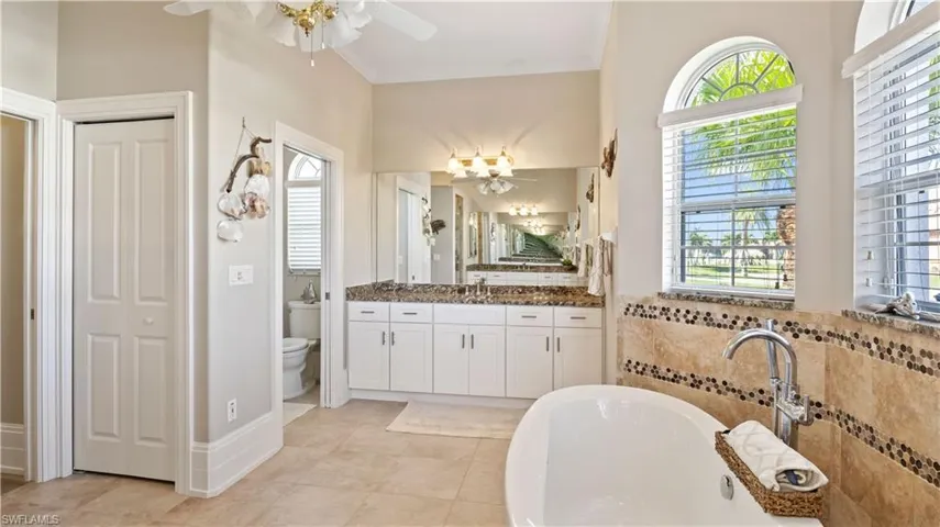 Beautiful travertine flooring, 11 inch 4 layered baseboards, his and hers dual vanity sinks and a large soaking tub and separate shower - this is a spa like retreat without ever leaving your home!
