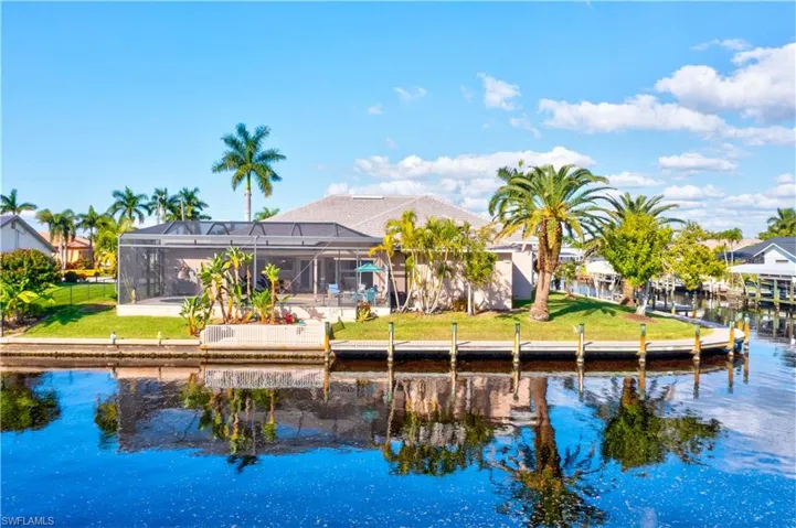 View of the home from the water!  WOWZA!!!!!  An oasis in the heart of the Southwest!   Beautiful palm trees and gardens, lush grass, an outdoor dock as well as extended captain's walk!  This home is large yet cozy, built by a celebrated and award winnig builder and is timeless!