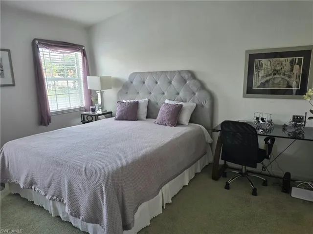 Carpeted bedroom featuring a desk