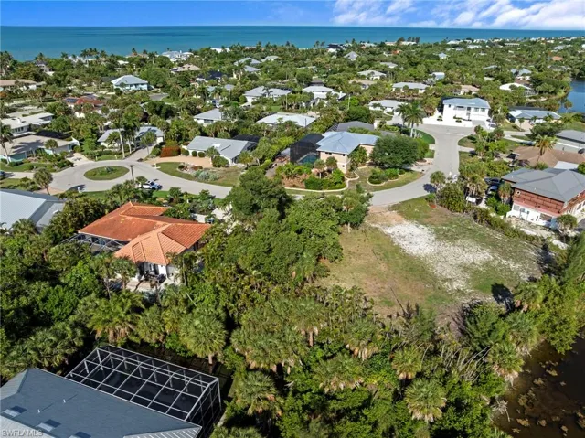 Expansive vacant lot featuring natural ground cover, mature landscaping, and water frontage