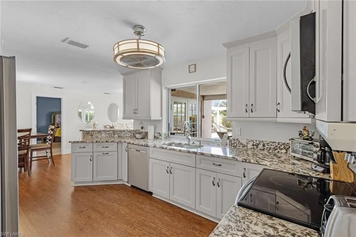Kitchen with sink, white cabinetry, dishwasher, and light wood-type flooring