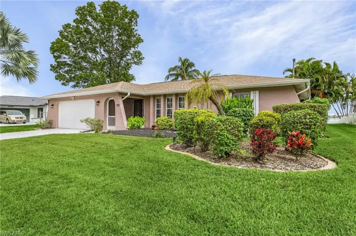Single story home featuring a garage and a front yard