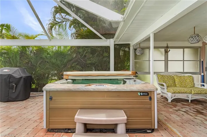 View of patio featuring grilling area and a hot tub