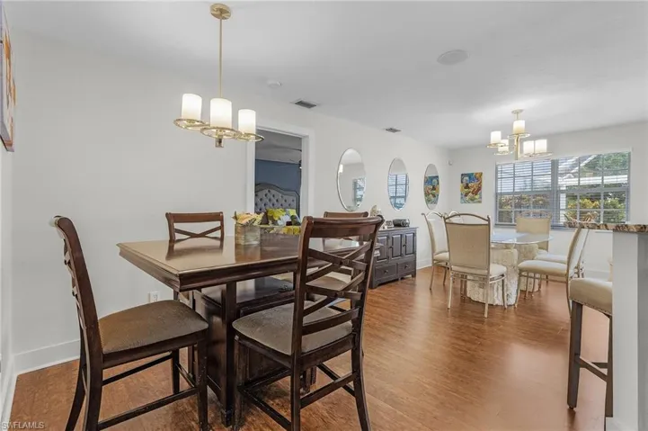 Dining space featuring dark wood-type flooring and an inviting chandelier