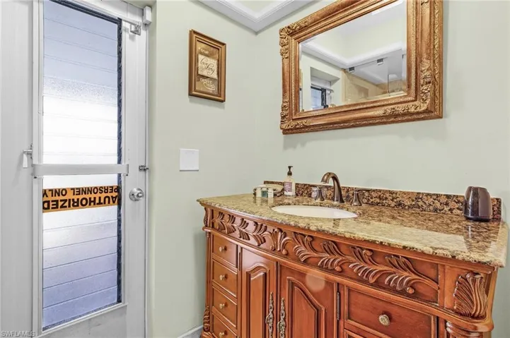 Bathroom with ornamental molding and vanity