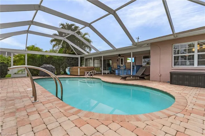 View of pool with a hot tub, ceiling fan, a patio area, and a lanai