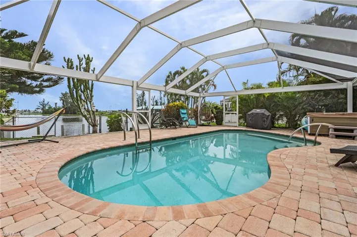View of pool featuring a patio area and glass enclosure
