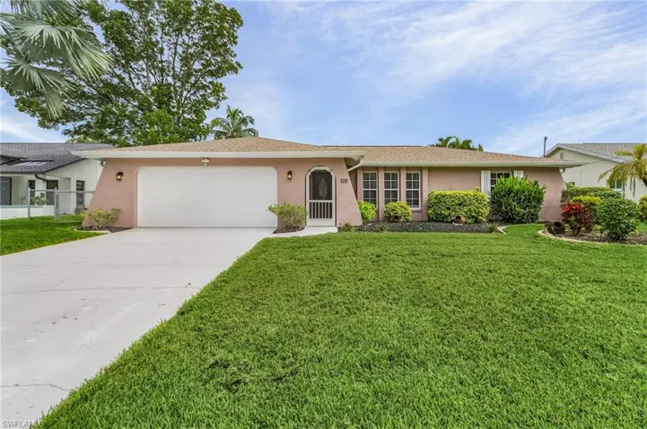 Ranch-style home featuring a garage and a front yard