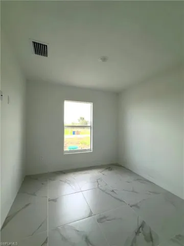 Unfurnished room with light marble finish flooring and baseboards