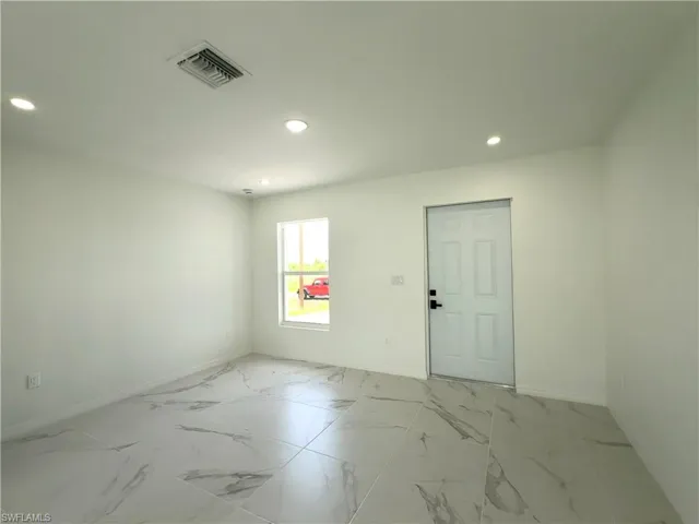 Unfurnished room with light marble finish floors and recessed lighting