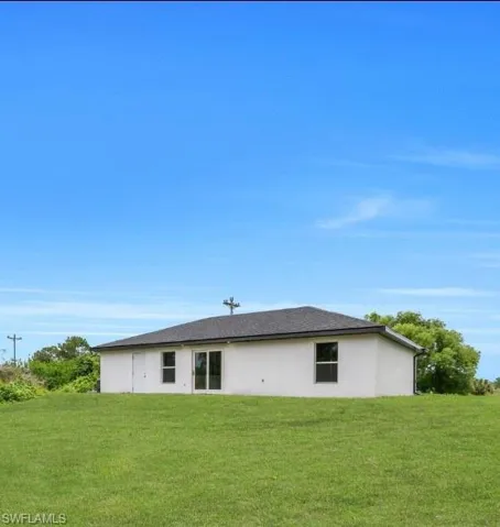Rear view of property featuring a yard