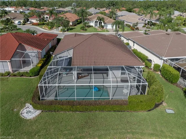View of the back of the home with a pool, integrated patio area, and surrounding manicured landscaping