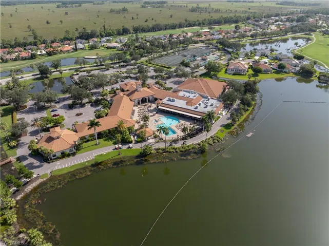 Community clubhouse with an outdoor swimming pool, multiple tennis courts, and golf course access