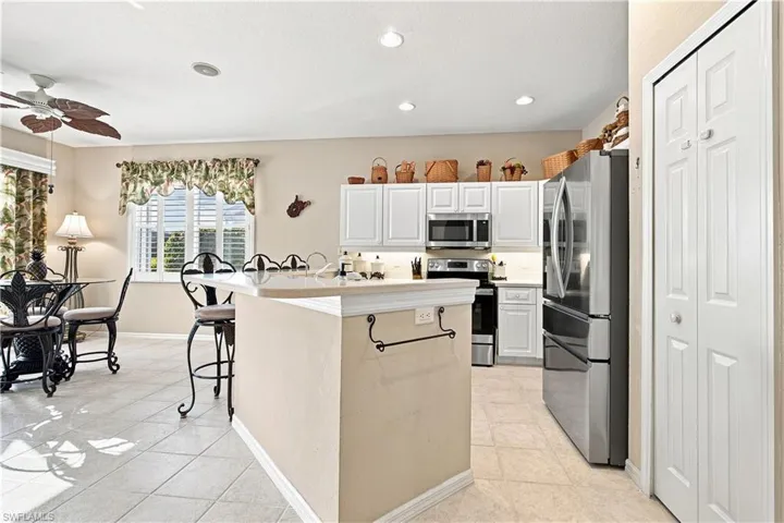 Kitchen featuring white cabinetry, stainless steel appliances, recessed lighting, and tile flooring