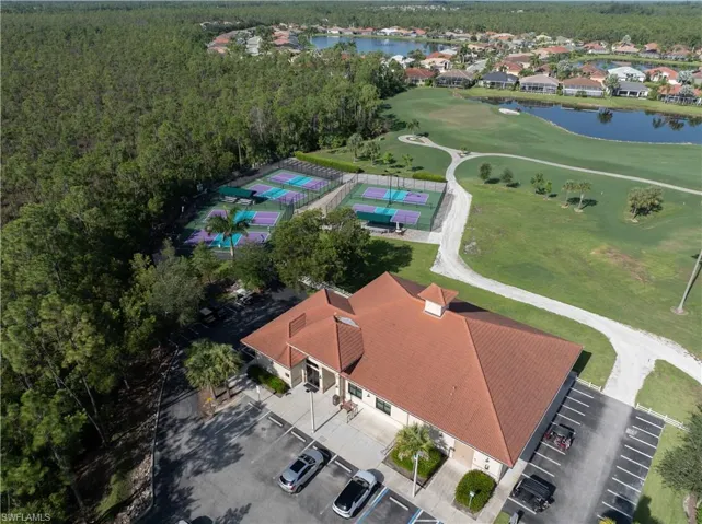 Fitness Center with an expansive parking area, multiple pickleball courts, and a golf course
