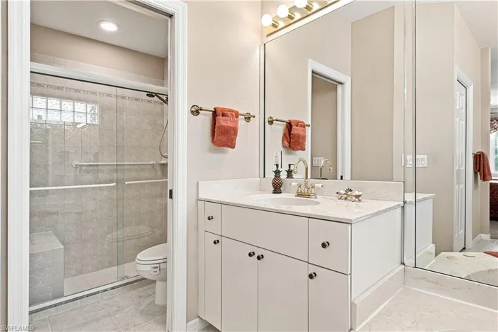 Vanity with a single basin sink, walk-in shower