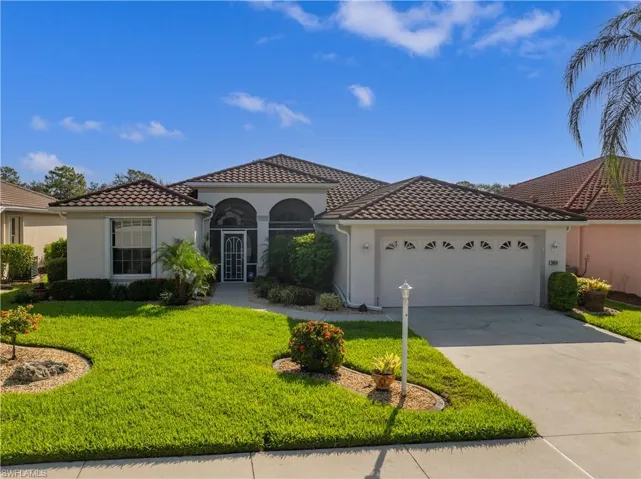 Exterior featuring a tiled roof, screened front entry, attached garage, concrete driveway, and landscaped front yard