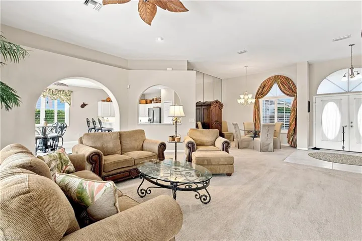 Arched doorways, a ceiling fan with decorative blades, and recessed lighting