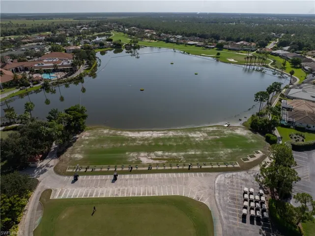 Expansive golf course and aquatic driving range featuring multiple hitting bays and a large natural water body