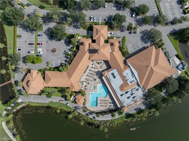Huge community center featuring a large building with multiple wings, abundant parking areas, a spacious outdoor pool