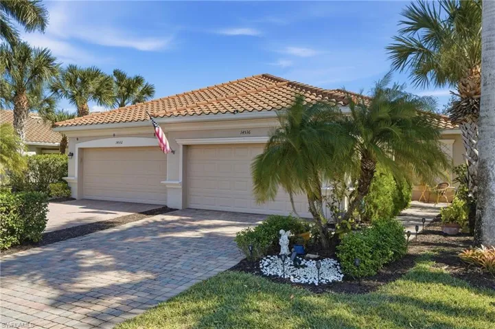 View of front of house featuring a tiled roof, stucco siding, and decorative driveway