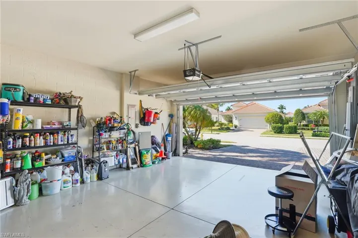 Garage featuring concrete block wall and a garage door opener