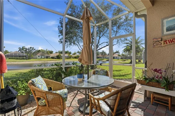 Sunroom featuring a residential view, a water view, outdoor dining space, and a patio area