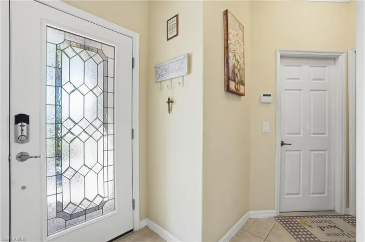 Entrance foyer with light tile patterned floors and baseboards