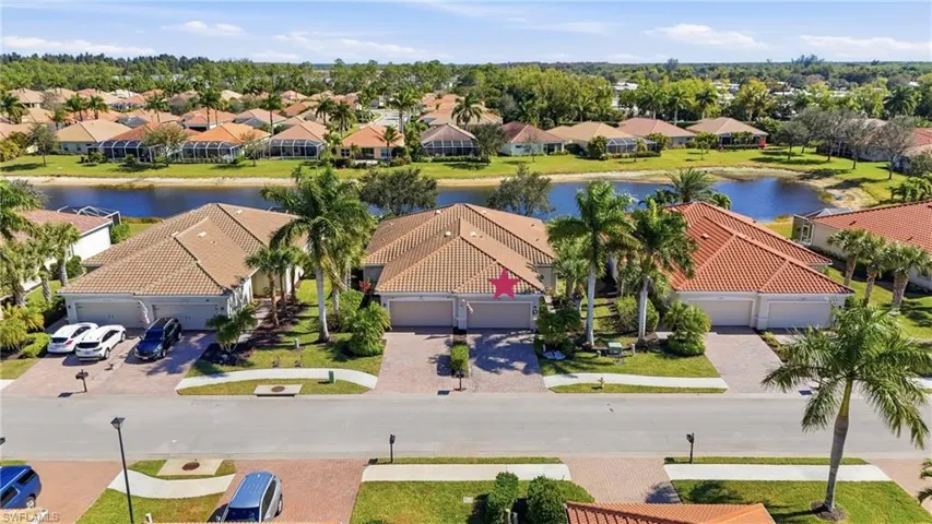 Aerial perspective of suburban area with a nearby body of water and a tree filled landscape