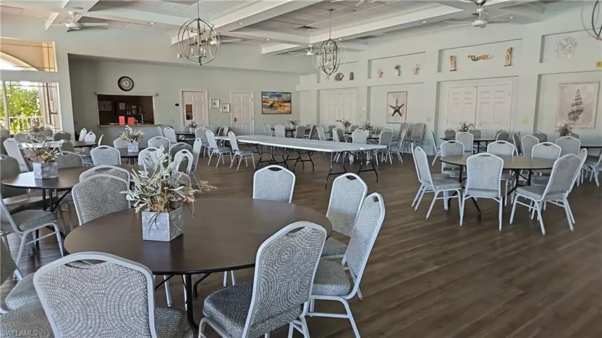 Dining area featuring a ceiling fan, coffered ceiling, dark wood-style flooring, and suspended lighting