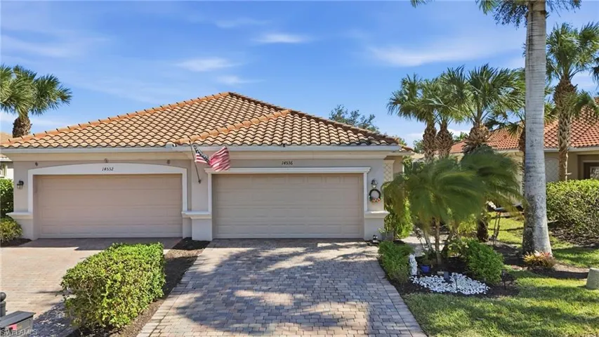 Mediterranean / spanish house with decorative driveway, stucco siding, and a tile roof
