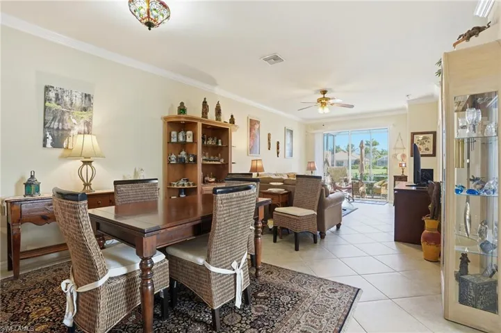 Dining room featuring ornamental molding, light tile patterned flooring, and ceiling fan